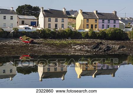 Stock Image - Colorful houses reflected in water; Portmagee, Iveragh Peninsula, County Kerry, Ireland, UK. Fotosearch