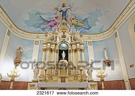 Stock Photo - Colorful religious depiction painted on ceiling of church with gold accents and candles at alter; Louisiana, New Orleans, USA. Fotosearch