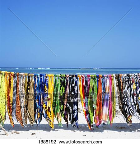 Stock Image - Colorful Sarongs Hanging Over White Sand Beach. Fotosearch