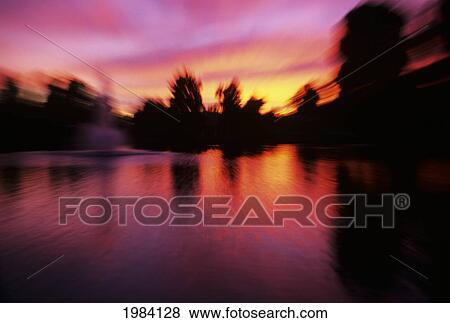 Stock Photo - Colorful Sunset Over Lake, Blurred Movement.. Fotosearch