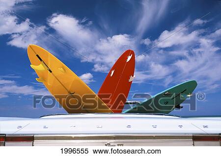 Stock Photography - Colorful Surfboards In Vintage Plymouth Fury Iii Car, Puffy Clouds In Background. Fotosearch