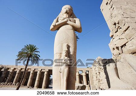Colossal Statue Of Ramses Ii With A Smaller Figure Of His Queen Nefertari Standing Between His Feet In The Great Court Of The Temple Of Amun In The Karnak Temple Complex, Luxor, Qina, Egypt View Large Photo Image Stock Photo - Colossal Statue Of Ramses Ii With A Smaller Figure Of His Queen Nefertari Standing Between His Feet In The Great Court Of The Temple Of Amun In The Karnak Temple Complex, Luxor, Qina, Egypt. Fotosearch