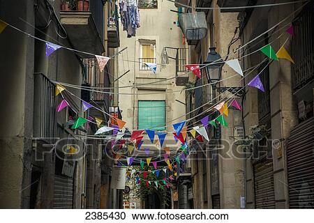 Stock Image - Coloured bunting decorating a street; Barcelona, Catalonia, Spain. Fotosearch