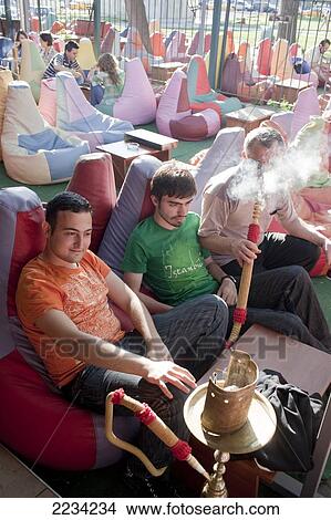 Picture - Colourful bean bags adorn the Tophane Narghile Cafes attracting a younger crowd to hang out, smoke Narghile smoking pipe, drink tea and play backgammon, close to the Istanbul Modern, Istanbul, Turkey. Photo. Fotosearch