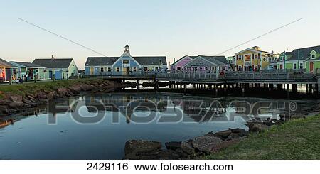 Stock Photograph - Colourful buildings in Spinnakers Landing reflected in tranquil water; Summerside, Prince Edward Island, Canada. Fotosearch