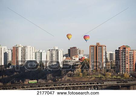 Stock Photo - Colourful Hot Air Balloons In The Sky Above The Buildings; Edmonton Alberta Canada. Fotosearch