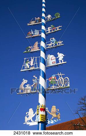 Stock Photo - Colourful images decorate a blue and white striped pole; Erling, Bavaria, Germany. Fotosearch