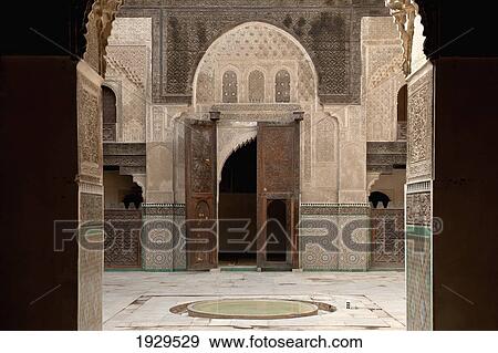 Stock Photo - Colourful patterned tile walls in a courtyard and wooden double doors; Fez, Morocco. Fotosearch