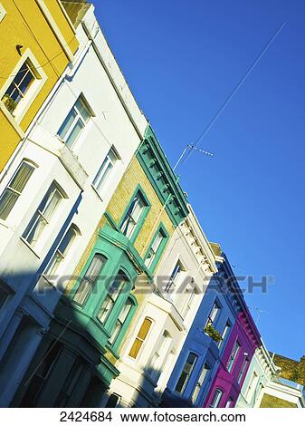 Picture - Colourful residential buildings in a row along Lancaster Road with a bright blue sky; London, England. Fotosearch