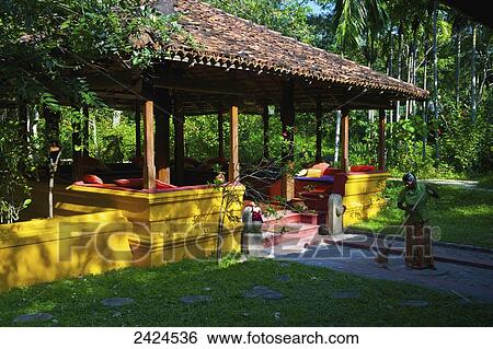 Colourful seating under a shelter surrounded by palm trees; Ulpotha, Embogama, Sri Lanka View Large Photo Image Stock Photograph - Colourful seating under a shelter surrounded by palm trees; Ulpotha, Embogama, Sri Lanka. Fotosearch