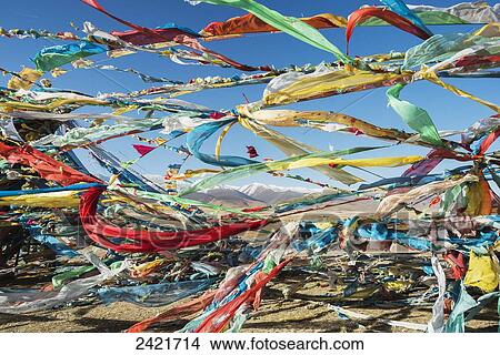 Colourful Tibetan prayer flags (Lung ta) under the strong wind with white mountain tops in the background; Qinghai province, Tibet View Large Photo Image Picture - Colourful Tibetan prayer flags (Lung ta) under the strong wind with white mountain tops in the background; Qinghai province, Tibet. Fotosearch