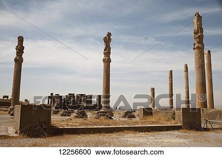 Stock Image - Columns of the Apadana Hall, and Winter Palace of Darius in background; Persepolis, Iran. Fotosearch