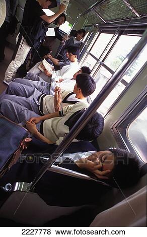 Commuters On A Busy Train / Subway Sleeping / Tired, Tokyo, Japan View Large Photo Image Stock Photo - Commuters On A Busy Train / Subway Sleeping / Tired, Tokyo, Japan. Fotosearch