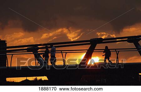 Stock Image - Commuters Walking On The Millennium Bridge At Sunset. Fotosearch