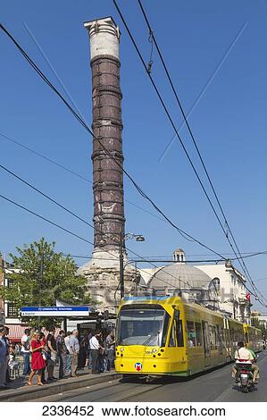 Stock Image - Constantine's Column In Yeniceriler Cadessi And Public Transport System Tram; Istanbul, Turkey. Fotosearch