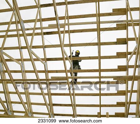 Construction Worker On Wooden Framework Of Building; Canada View Large Photo Image Stock Photo - Construction Worker On Wooden Framework Of Building; Canada. Fotosearch