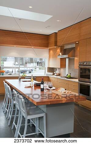 Stock Image - Contemporary Kitchen With Breakfast Bar And Stools; Victoria, Vancouver Island, British Columbia, Canada. Fotosearch