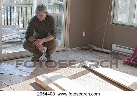 Stock Photo - Contractor Looking At Blue Prints In A New Home, Ontario. Fotosearch