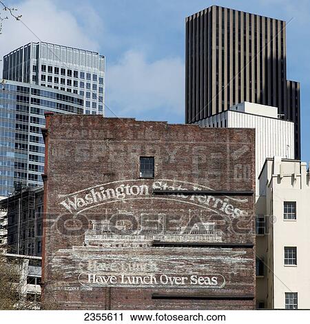 Stock Image - Contrast Of Old And Modern Buildings With A Painted Advertisement For Washington State Ferries; Seattle, Washington, United States Of America. Fotosearch