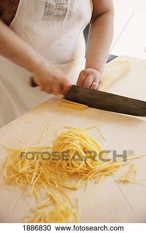 Cook Making Tagliatelli Pasta By Cutting Rolled-Up Sheet Of Pasta, La Vecchia Scuola View Large Photo Image Stock Image - Cook Making Tagliatelli Pasta By Cutting Rolled-Up Sheet Of Pasta, La Vecchia Scuola. Fotosearch