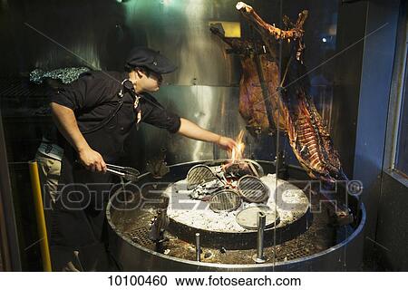Stock Image - Cooking over an open flame; El Calafate, Argentina. Fotosearch