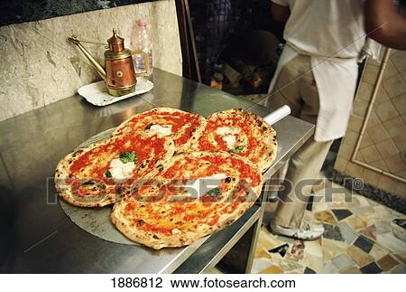 Stock Image - Cooking Pizzas, Freshly Baked Pizza At Naples. Fotosearch