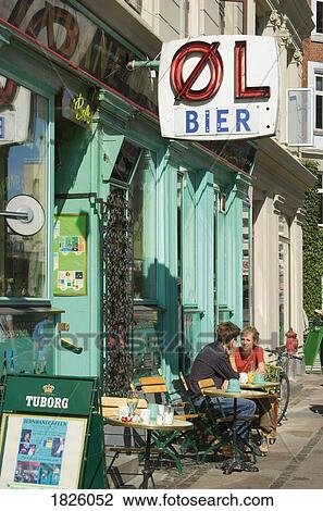 Stock Image - Copenhagen, Denmark; Young Couple Sitting At Sidewalk Cafe. Fotosearch