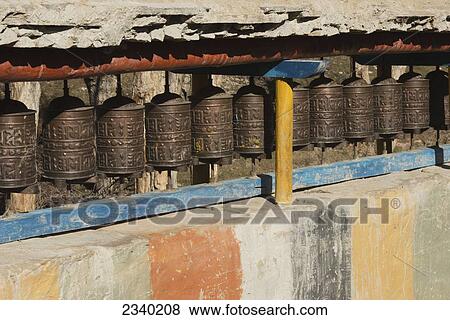 Copper Prayer Wheels And Painted Wall; Geling, Upper Mustang Valley, Nepal View Large Photo Image Stock Photo - Copper Prayer Wheels And Painted Wall; Geling, Upper Mustang Valley, Nepal. Fotosearch