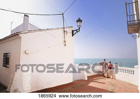 Picture - Couple Admiring Sea View From Balcony On Calle Carabeo, Nerja, Costa Del Sol, Malaga, Spain. Fotosearch