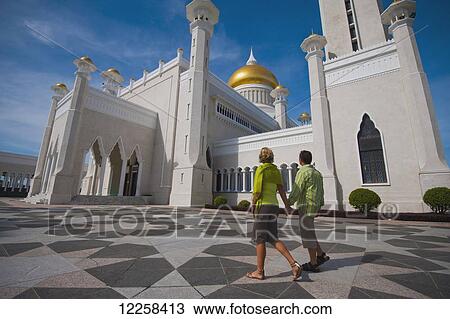 Stock Image - Couple at Sultan Omar Ali Saifuddien Mosque; Bandar Seri Begawan, Brunei. Fotosearch