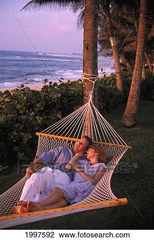 Couple At Sunset, Relaxing In Hammock In Tropical Setting. Hawaii View Large Photo Image Stock Image - Couple At Sunset, Relaxing In Hammock In Tropical Setting. Hawaii. Fotosearch