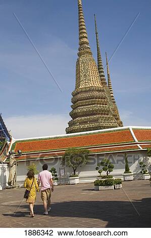 Stock Image - Couple At Wat Pho With Western Courtyard Chedis In Background. Fotosearch