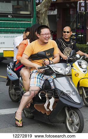 Stock Photo - Couple carrying their dog on a motorcycle, Suzhou, Jiangsu, China. Fotosearch