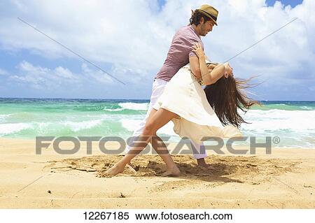 Stock Photography - Couple dancing on the beach; Kealia, Kauai, Hawaii, United States of America. Fotosearch