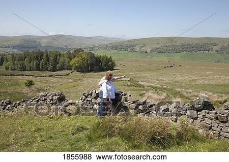 Stock Photo - Couple Embracing By Rustic Stone Fence, Dumfries And Galloway, Scotland. Fotosearch
