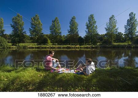Couple Having Picnic On The Banks Of The Nantes-Brest Canal View Large Photo Image Stock Photo - Couple Having Picnic On The Banks Of The Nantes-Brest Canal. Fotosearch