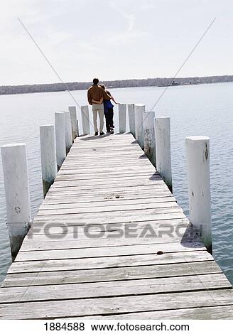 Stock Photo - Couple Hugging At The End Of A Pier. Fotosearch