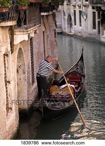 Stock Photograph - Couple In Gondola On Canal, Rear View; Venice, Italy. Fotosearch