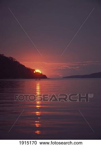 Stock Image - Couple In Kayak Beside Small Island. Fotosearch