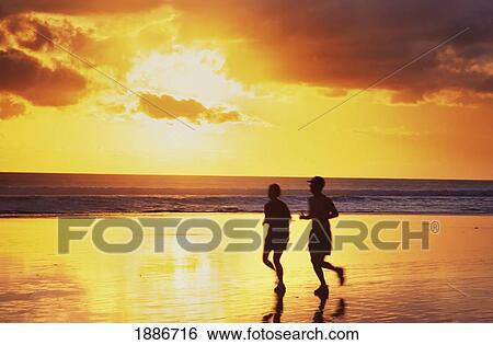 Couple Jogging On Seminyak Beach At Sunset View Large Photo Image Stock Photograph - Couple Jogging On Seminyak Beach At Sunset. Fotosearch