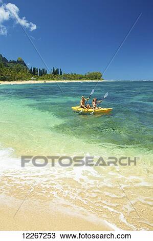 Stock Image - Couple kayaking; Kauai, Hawaii, United States of America. Fotosearch