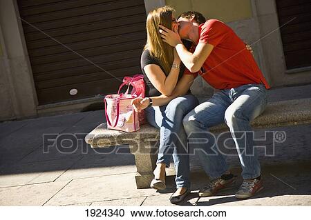 Stock Image - Couple Kissing On Street Bench, Turin, Italy. Fotosearch