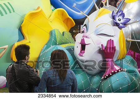 Couple Looking At Large Falla Displayed On Street As Part Of Fallas Festival; Valencia, Spain View Large Photo Image Picture - Couple Looking At Large Falla Displayed On Street As Part Of Fallas Festival; Valencia, Spain. Fotosearch
