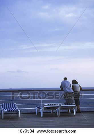 Couple Looking Out From Deck Of Cruise Ship At Dusk View Large Photo Image Picture - Couple Looking Out From Deck Of Cruise Ship At Dusk. Fotosearch