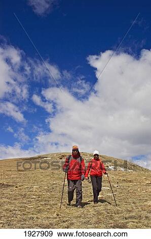Couple Of Hikers Walking Down Slope, Alberta, Canada View Large Photo Image Stock Photo - Couple Of Hikers Walking Down Slope, Alberta, Canada. Fotosearch