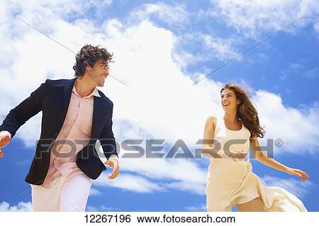 Stock Photograph - Couple on a beach; Kealia, Kauai, Hawaii, United States of America. Fotosearch