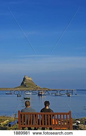 Couple On Bench Looking Towards Lindisfarne Castle. View Large Photo Image Stock Image - Couple On Bench Looking Towards Lindisfarne Castle.. Fotosearch
