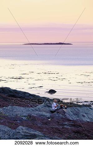 Stock Photo - Couple On Shore Of Saguenay-St. Lawrence Marine Park; Ile-Aux-Lievres Quebec Canada. Fotosearch