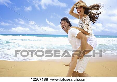 Stock Photo - Couple on the beach; Kealia, Kauai, Hawaii, United States of America. Fotosearch