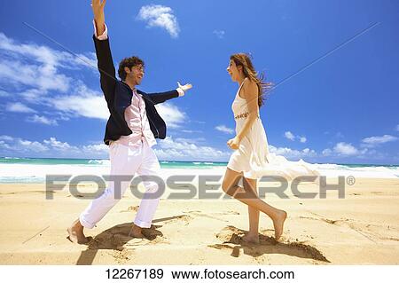 Stock Photo - Couple on the beach; Kealia, Kauai, Hawaii, United States of America. Fotosearch